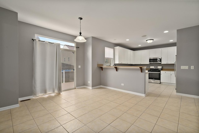 8013 Shady Oak Rd, Joliet, IL 60431 - kitchen featuring appliances with stainless steel finishes, a peninsula, white cabinets, light tile patterned floors, and recessed lighting