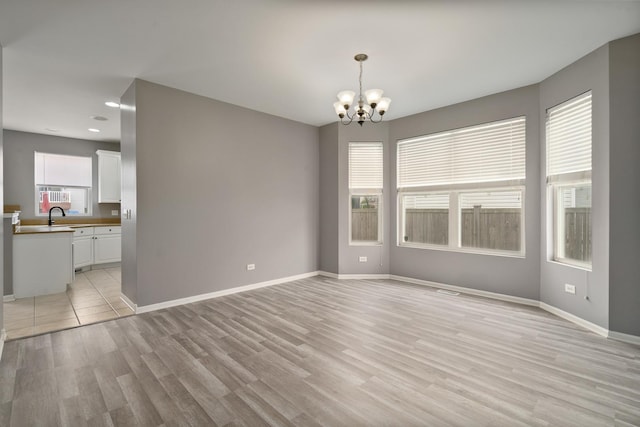 8013 Shady Oak Rd, Joliet, IL 60431 - unfurnished dining area featuring a chandelier, light wood-type flooring, baseboards, a sink, and recessed lighting