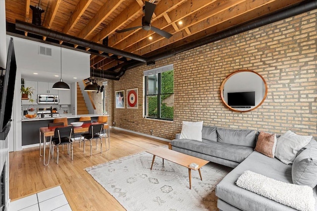 2943 N Lincoln Ave Unit 202, Chicago, IL 60657 - living room featuring brick wall, ceiling fan, and light wood-style floors