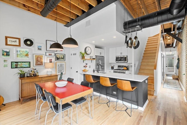 2943 N Lincoln Ave Unit 202, Chicago, IL 60657 - dining space with a towering ceiling, stairs, and light wood finished floors