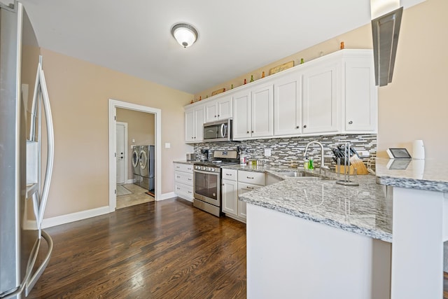 10749 Revere Cir, Mokena, IL 60448 - kitchen with stainless steel appliances, washer and dryer, white cabinets, and light stone countertops