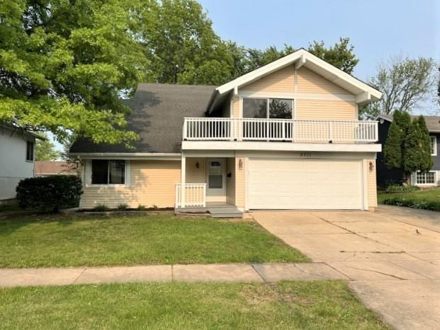 5711 Ring Ct, Hanover Park, IL 60133 - view of front facade featuring a balcony, concrete driveway, an attached garage, and a front yard