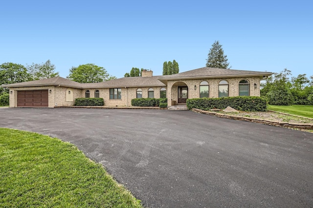 406 Lauder Ln, Inverness, IL 60067 - view of front of home with a chimney, brick siding, driveway, and an attached garage