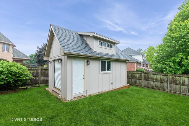 13103 W Beaver Lake Dr, Homer Glen, IL 60491 - back of property featuring board and batten siding, a fenced backyard, an outbuilding, and a shingled roof