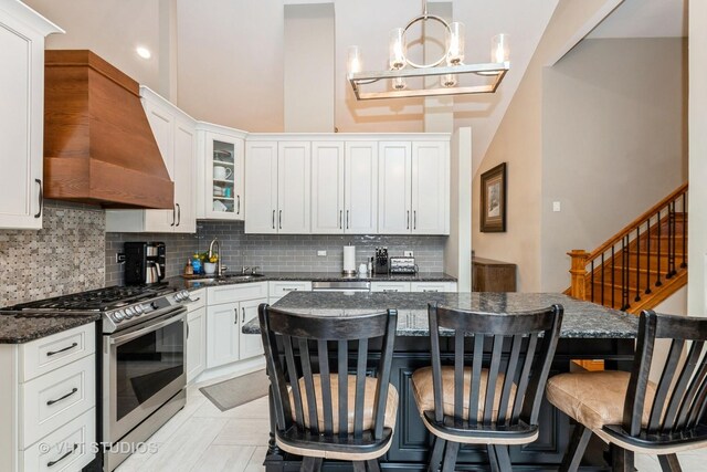 13103 W Beaver Lake Dr, Homer Glen, IL 60491 - kitchen with gas range, custom range hood, backsplash, a breakfast bar area, and white cabinetry