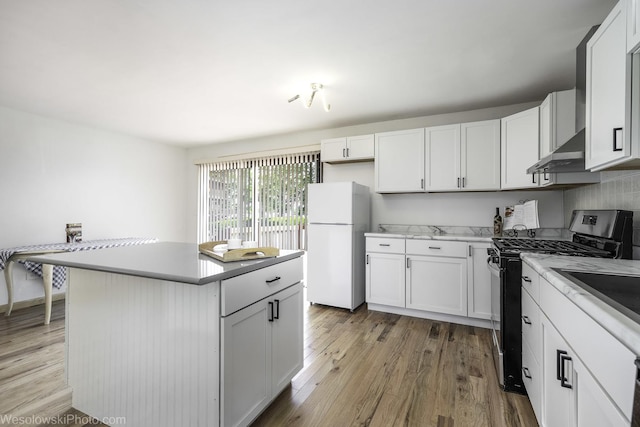23314 W Liberty Ave, Lake Villa, IL 60046 - kitchen with stainless steel gas range oven, freestanding refrigerator, ventilation hood, and light wood-style flooring