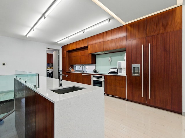 7415 W Main St, Niles, IL 60714 - kitchen with modern cabinets, a sink, oven, light countertops, and brown cabinetry