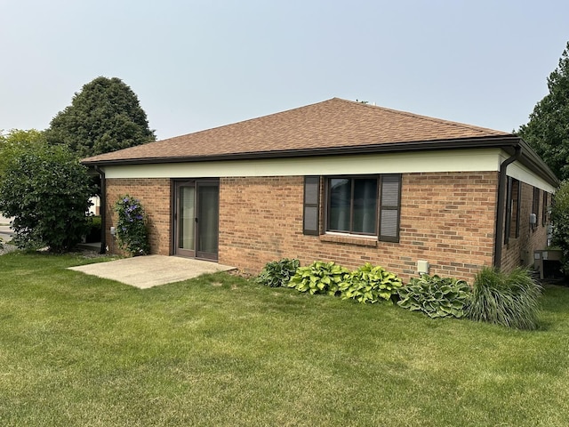 2406A Coventry Ct Unit 2406, Sterling, IL 61081 - rear view of property featuring a lawn, brick siding, roof with shingles, and cooling unit