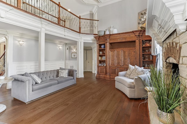 14151 131st St, Lemont, IL 60439 - living room featuring a towering ceiling, wood finished floors, decorative columns, a decorative wall, and a fireplace