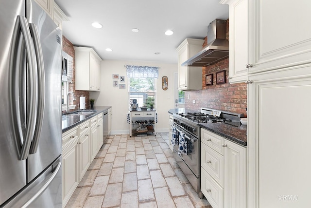 735 S Spring Rd, Elmhurst, IL 60126 - kitchen featuring stainless steel appliances, wall chimney range hood, a sink, brick flooring, and baseboards