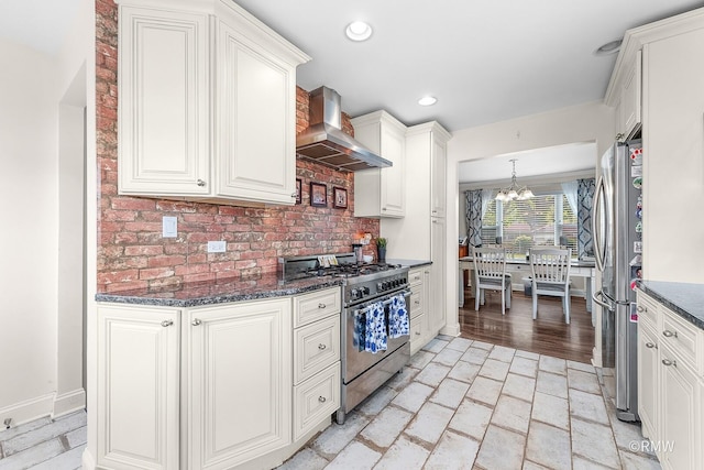 735 S Spring Rd, Elmhurst, IL 60126 - kitchen featuring stainless steel appliances, wall chimney exhaust hood, white cabinets, a chandelier, and tasteful backsplash