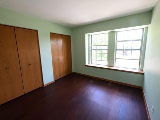 1740 Somerfield Ln, Crystal Lake, IL 60014 - unfurnished bedroom with two closets, dark wood finished floors, and baseboards