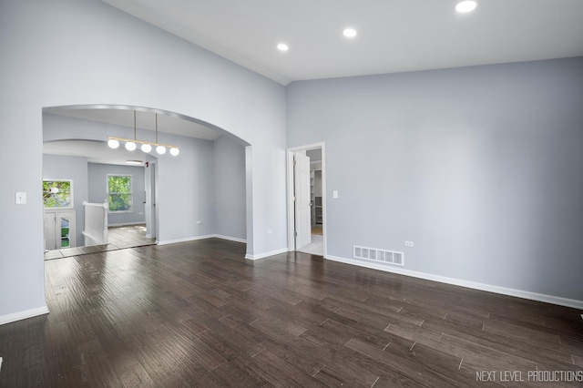 3023 Saganashkee Ln, Naperville, IL 60564 - empty room featuring arched walkways, dark wood finished floors, baseboards, recessed lighting, and lofted ceiling