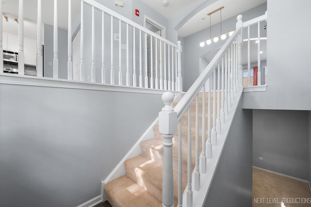 3023 Saganashkee Ln, Naperville, IL 60564 - stairs featuring arched walkways, carpet, and baseboards