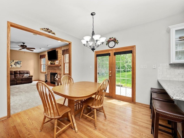 3445 W 114th St, Chicago, IL 60655 - dining area with a fireplace, light wood-style floors, french doors, a chandelier, and baseboards