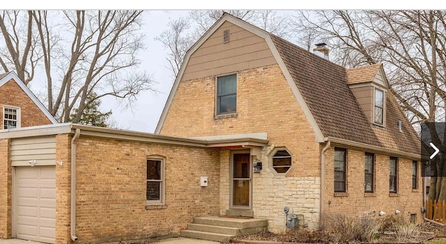 288 N Prairie Ave, Mundelein, IL 60060 - view of front of home featuring a chimney, brick siding, a gambrel roof, and an attached garage