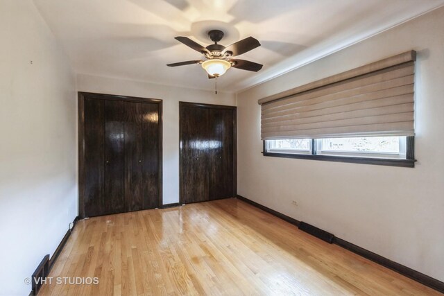 5341 S Austin Ave, Chicago, IL 60638 - unfurnished bedroom with multiple closets, wood finished floors, baseboards, and a ceiling fan