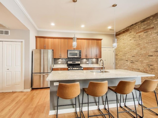 834 N Wood St Unit 2N, Chicago, IL 60622 - kitchen featuring stainless steel appliances, a sink, an island with sink, a breakfast bar, and crown molding