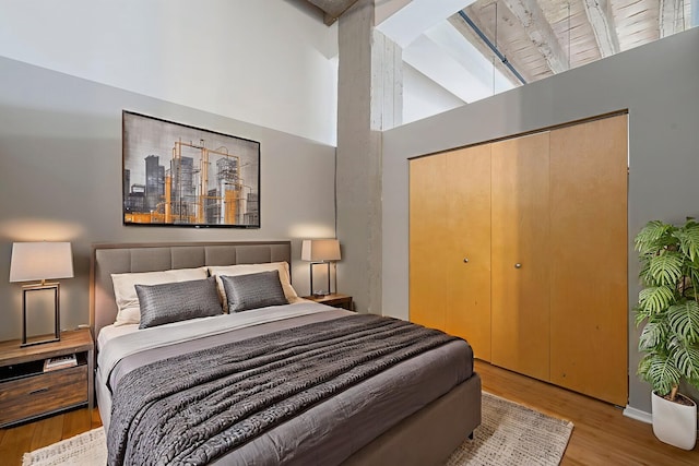 1645 W Ogden Ave Unit 515, Chicago, IL 60612 - bedroom with wood finished floors, high vaulted ceiling, a closet, and beam ceiling