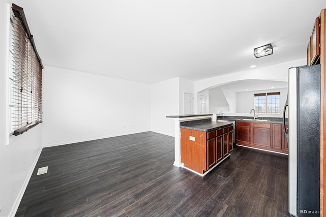 10651 Gabrielle Ln, Orland Park, IL 60462 - kitchen with freestanding refrigerator, arched walkways, dark wood-type flooring, a sink, and dark countertops