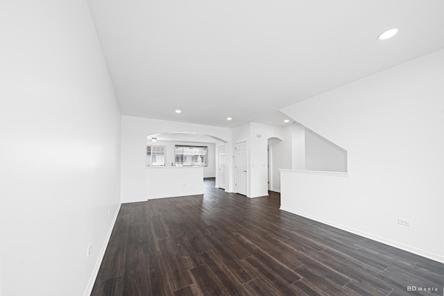 10651 Gabrielle Ln, Orland Park, IL 60462 - unfurnished living room featuring arched walkways, recessed lighting, dark wood-type flooring, and baseboards