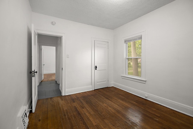 487 S Lincoln Ave, Kankakee, IL 60901 - unfurnished bedroom with dark wood finished floors, baseboards, and a textured ceiling