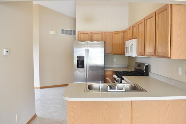 14635 Euclid St Unit D, Cedar Lake, IN 46303 - kitchen featuring appliances with stainless steel finishes, a peninsula, light countertops, light tile patterned floors, and vaulted ceiling