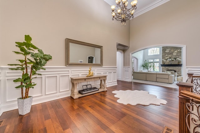 217 Haman Rd, Inverness, IL 60010 - living area with a stone fireplace, a chandelier, wood finished floors, a wainscoted wall, and a decorative wall