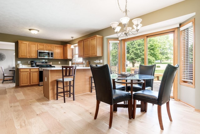 5804 Targee Trl, Roscoe, IL 61073 - dining area with light wood-type flooring, a chandelier, and baseboards