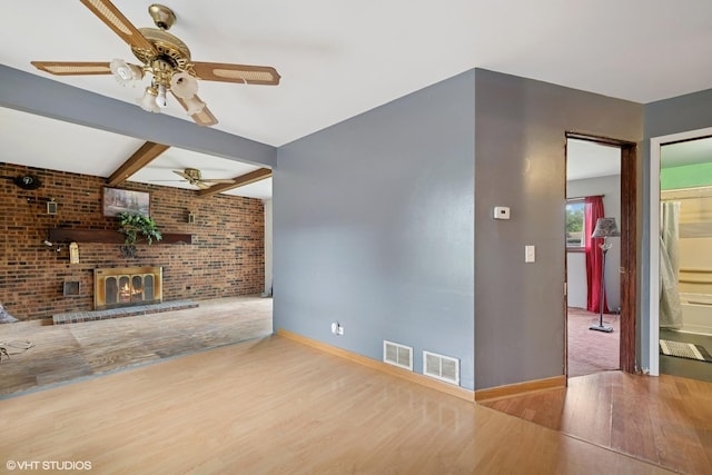 908 Diana Ct, Round Lake Beach, IL 60073 - unfurnished living room featuring wood finished floors, ceiling fan, baseboards, brick wall, and a brick fireplace