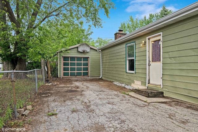 908 Diana Ct, Round Lake Beach, IL 60073 - view of side of home featuring a chimney, driveway, an outbuilding, and a garage