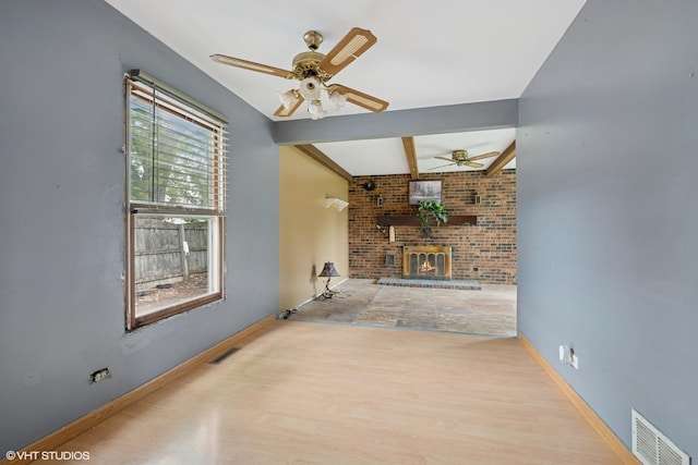 908 Diana Ct, Round Lake Beach, IL 60073 - unfurnished living room with a ceiling fan, wood finished floors, beam ceiling, a brick fireplace, and baseboards