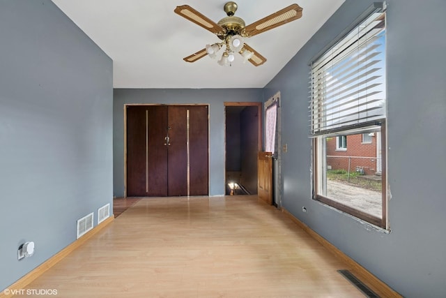908 Diana Ct, Round Lake Beach, IL 60073 - unfurnished bedroom featuring multiple windows, wood finished floors, two closets, and baseboards