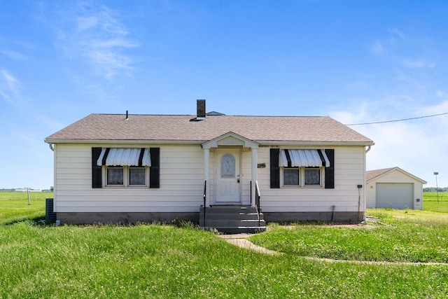 7832 Main St, Walsh, IL 62297 - bungalow featuring a chimney, a front yard, a garage, a shingled roof, and entry steps
