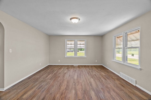 7832 Main St, Walsh, IL 62297 - unfurnished room featuring arched walkways, dark wood-type flooring, and baseboards
