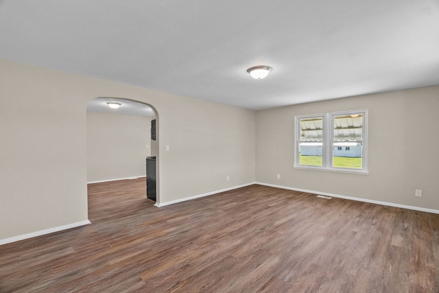 7832 Main St, Walsh, IL 62297 - empty room with arched walkways, wood finished floors, and baseboards