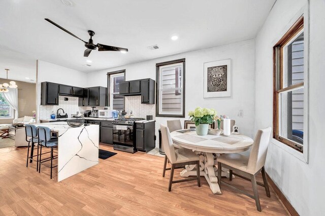 4926 S Winchester Ave, Chicago, IL 60609 - kitchen with black gas stove, dark cabinets, decorative backsplash, light wood-style flooring, and recessed lighting