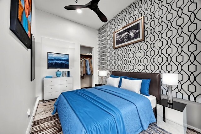 4926 S Winchester Ave, Chicago, IL 60609 - bedroom with an accent wall, baseboards, wallpapered walls, a spacious closet, and ceiling fan