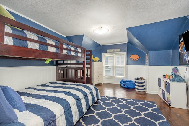 614 Oak Ave, Aurora, IL 60506 - bedroom featuring vaulted ceiling, wood finished floors, wainscoting, and a textured ceiling