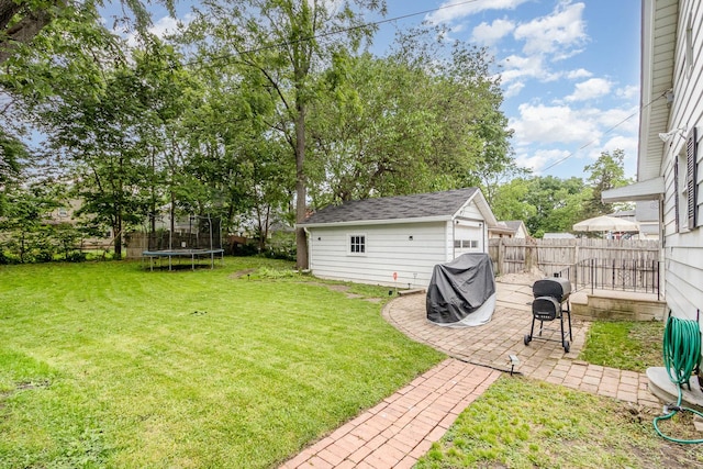 614 Oak Ave, Aurora, IL 60506 - view of yard featuring a trampoline, a patio, and an outbuilding