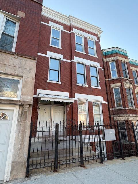 2307 S Leavitt St, Chicago, IL 60608 - townhome / multi-family property with a fenced front yard and brick siding