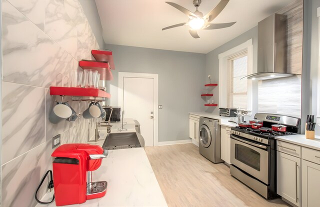 2307 S Leavitt St, Chicago, IL 60608 - kitchen with stainless steel gas range, washer / clothes dryer, wall chimney range hood, a ceiling fan, and light countertops