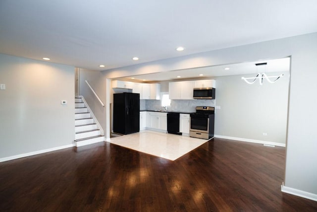 14117 S Calhoun Ave, Burnham, IL 60633 - kitchen with black appliances, white cabinetry, wood finished floors, baseboards, and a chandelier