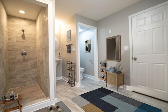 14117 S Calhoun Ave, Burnham, IL 60633 - bathroom featuring a tile shower, toilet, wood finished floors, baseboards, and vanity