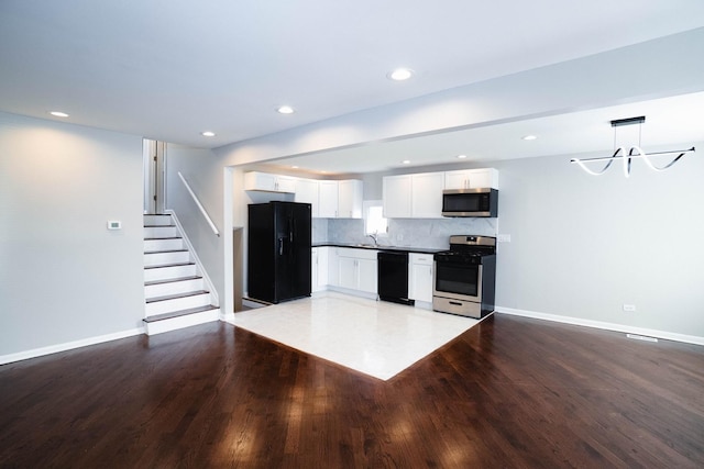 14117 S Calhoun Ave, Burnham, IL 60633 - kitchen featuring black appliances, dark countertops, white cabinetry, baseboards, and light wood-style floors
