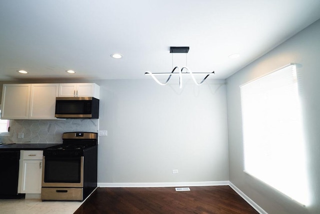 14117 S Calhoun Ave, Burnham, IL 60633 - kitchen with appliances with stainless steel finishes, backsplash, dark countertops, recessed lighting, and light wood-style flooring