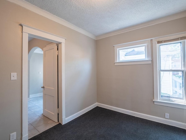 8950 S Bishop St, Chicago, IL 60620 - spare room featuring arched walkways, a textured ceiling, ornamental molding, baseboards, and dark carpet