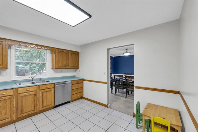 1803 Galena St, Urbana, IL 61802 - kitchen with stainless steel dishwasher, brown cabinets, light countertops, light tile patterned floors, and light colored carpet