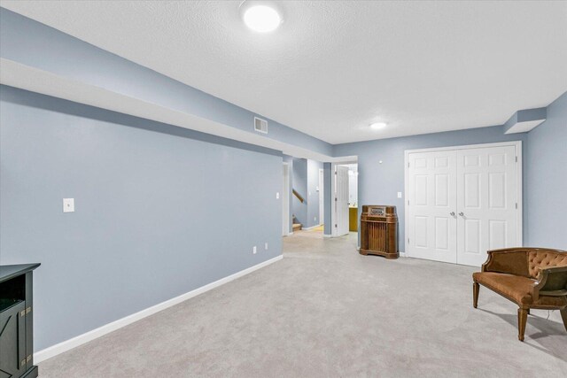 1803 Galena St, Urbana, IL 61802 - sitting room with light carpet, stairway, and a textured ceiling