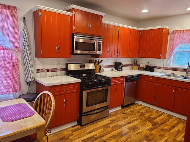 100 Watson Ave, Oglesby, IL 61348 - kitchen featuring appliances with stainless steel finishes, a sink, backsplash, light countertops, and dark wood-style flooring